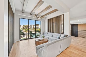 A modern living room with a grey sofa and a view of the city.